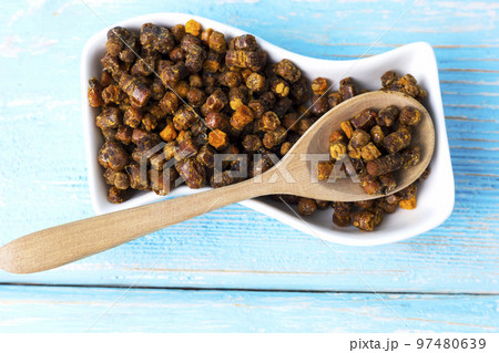 bee parchment in a wooden spoon, close-up. Vitamins, benefits. bee parchment in a wooden spoon, close-up. Vitamins, benefits. 97480639