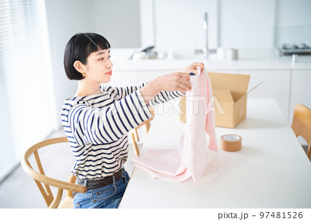 衣類を手にする若い女性 97481526