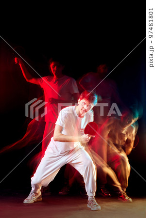young man playing table tennis in mixed neon light 97481801