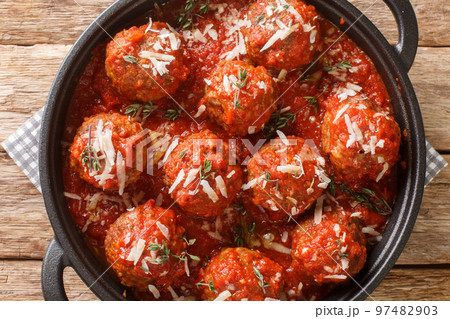 Italian Traditional Dish Polpette al sugo meatballs in tomato sauce on pan on wooden table. Horizontal top view Italian Traditional Dish Polpette al sugo meatballs in tomato sauce on pan on wooden table. Horizontal top view 97482903
