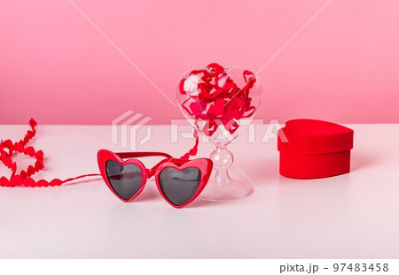 Valentines day concept. Hearts ribbon and red shaped glasses, box with engagement rings 97483458