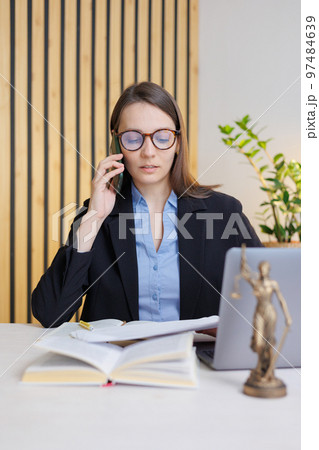 female lawyer in strict suit works in office or court, checks clients' contracts. Caucasian successful business lady. talks on phone 97484639