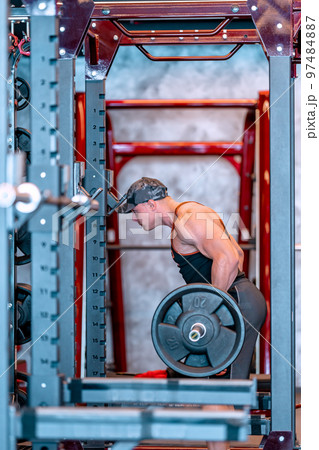 young athlete lifts barbell in gym young athlete lifts barbell in gym 97484887
