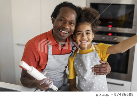 Cute Black Girl Taking Selfie With Her Dad While Cooking In Kitchen 97486689