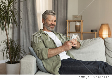 New normal for retired people. Smiling old caucasian male typing on smartphone uses new app for chat 97487137