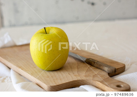 An Apple on a Bamboo Cutting Board. 97489636