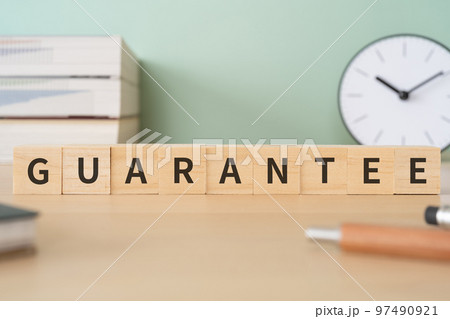 GUARANTEEと書かれたブロックが置かれたデスク 97490921