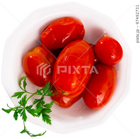 Juicy marinated tomatoes served on plate decorated with parsle. Homemade canning. Pickled vegetables Juicy marinated tomatoes served on plate decorated with parsle. Homemade canning. Pickled vegetables 97492731