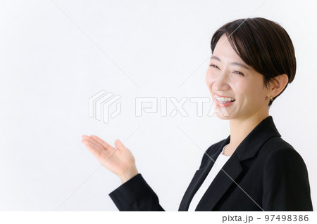 スーツ姿でオススメのポーズをする使いやすいビジネス系女性の黒スーツのイメージ 97498386