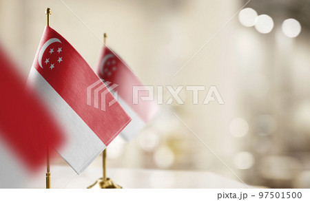 Small flags of the Singapore on an abstract blurry background Small flags of the Singapore on an abstract blurry background 97501500
