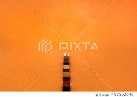 アイデアを思いつき電球がウッドキューブの頂点に点灯するオレンジ色の背景 97502640