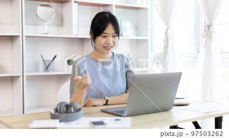 Young Asian women are greeting friends and teachers through video chats and greeting them with cheerful expressions, Online communication , Stay home, New normal, VDO Call, Social distancing 97503262