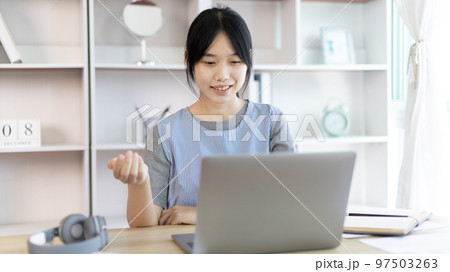 Young Asian women are greeting friends and teachers through video chats and greeting them with cheerful expressions, Online communication , Stay home, New normal, VDO Call, Social distancing 97503263