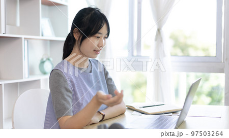 Young Asian women are greeting friends and teachers through video chats and greeting them with cheerful expressions, Online communication , Stay home, New normal, VDO Call, Social distancing 97503264