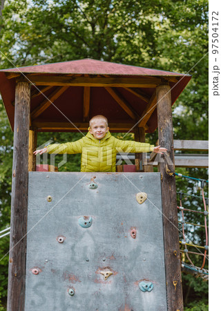 Boy At The Climbing Wall Without A Helmet, Danger At The Climbing Wall. Little Boy Climbing A Rock Wall Indoor 97504172