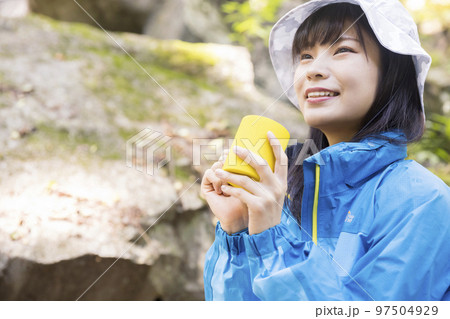 山歩きの途中で飲み物を飲んで休憩をする女性 トレッキングイメージ 山歩きの途中で飲み物を飲んで休憩をする女性 トレッキングイメージ 97504929