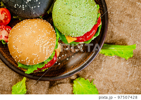 Top down view of set of three mini color homemade burgers with marble beef on rustic table 97507428
