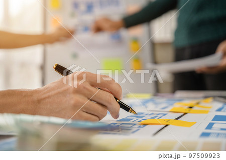 UI developer and ui designer brainstorming about mobile app interface wireframe design with customer breif and color code at office. 97509923