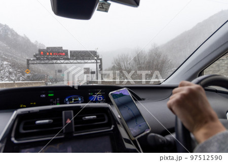 冬に雪が積もり始めた高速道路を走行する乗用車の運転席からの眺め 冬に雪が積もり始めた高速道路を走行する乗用車の運転席からの眺め 97512590