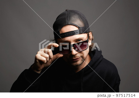 Smiling Man in Hat and sunglasses. Happy Boy in a hoodie 97517514