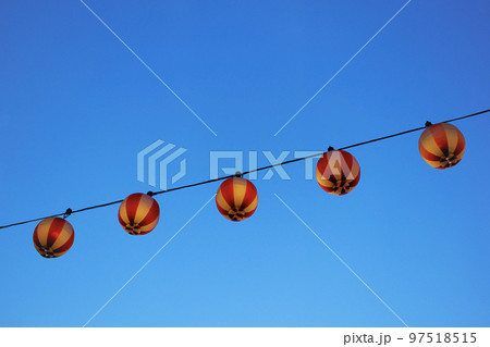 夏祭りの赤い提灯が飾り付けられている風景と綺麗な青空 夏祭りの赤い提灯が飾り付けられている風景と綺麗な青空 97518515