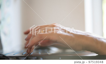 Low angle closeup view of female hands using laptop computer 97519348