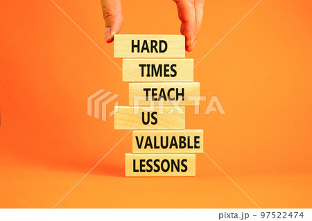 Lesson from hard times symbol. Concept words Hard times teach us valuable lessons on wooden blocks on a beautiful orange background. Businessman hand. Business lesson from hard times concept. Lesson from hard times symbol. Concept words Hard times teach us valuable lessons on wooden blocks on a beautiful orange background. Businessman hand. Business lesson from hard times concept. 97522474