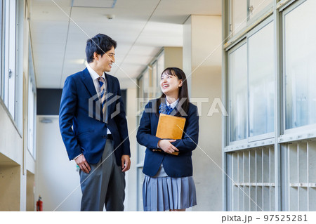 廊下を歩く制服姿の男女高校生 97525281