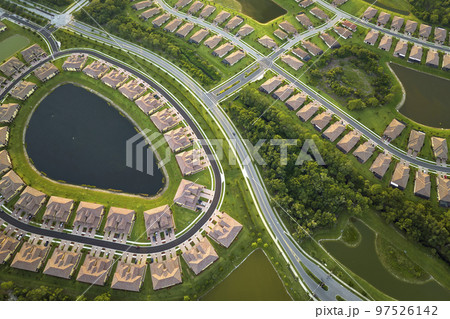 View from above of densely built residential houses near retention ponds in closed living clubs in south Florida. American dream homes as example of real estate development in US suburbs 97526142