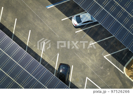 Solar panels installed over parking lot for parked cars for effective generation of clean energy Solar panels installed over parking lot for parked cars for effective generation of clean energy 97526266