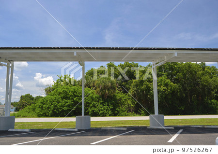 Solar panels installed over parking lot canopy shade for parked cars for effective generation of clean energy 97526267
