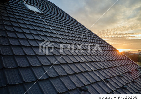 Snow guard for safety in winter on house roof top covered with steel shingles. Tiled covering of building Snow guard for safety in winter on house roof top covered with steel shingles. Tiled covering of building 97526268