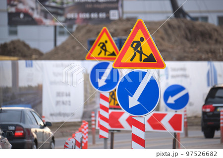 Roadworks warning traffic signs of construction work on city street and slowly moving cars 97526682