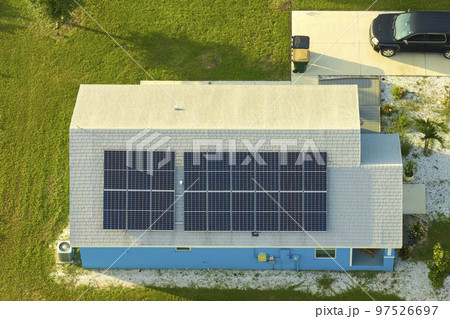 Residential house with rooftop covered with solar photovoltaic panels for producing of clean ecological electrical energy in suburban rural area. Concept of autonomous home Residential house with rooftop covered with solar photovoltaic panels for producing of clean ecological electrical energy in suburban rural area. Concept of autonomous home 97526697