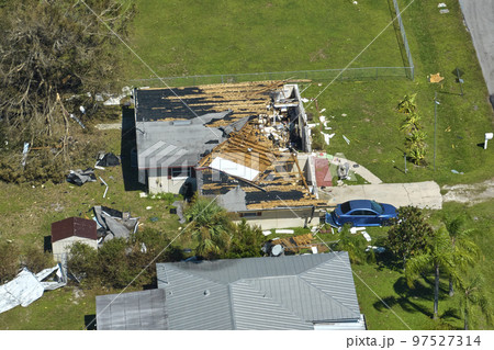 Hurricane Ian destroyed house roof in Florida residential area. Natural disaster and its consequences 97527314