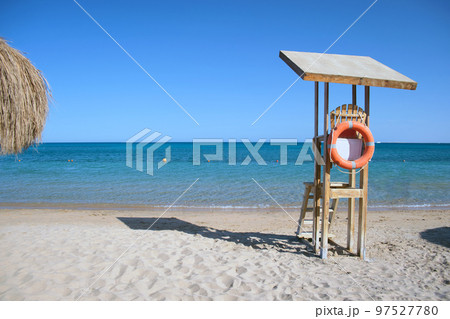 Emplty wooden lifeguard station on sandy beach on ocean shore in summer Emplty wooden lifeguard station on sandy beach on ocean shore in summer 97527780
