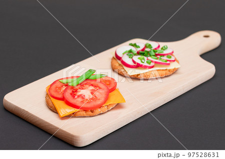 Different Cracker Sandwiches with Tomato, Cucumber, Radish and Cheese 97528631
