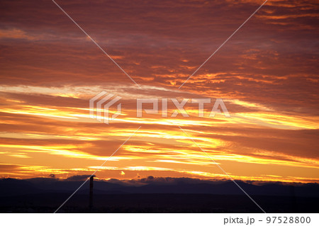 Bright colorful sunset sky with rays of setting sun and vivid dark clouds 97528800