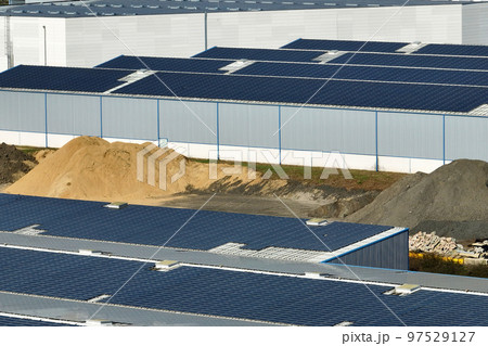 Aerial view of solar power plant with blue photovoltaic panels mounted on industrial building roof for producing green ecological electricity. Production of sustainable energy concept 97529127