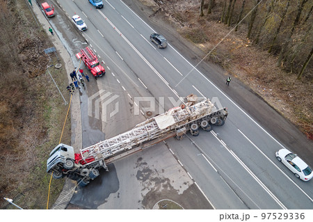 Aerial view of road accident with overturned truck blocking traffic Aerial view of road accident with overturned truck blocking traffic 97529336