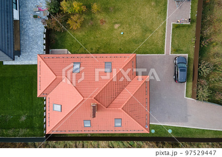 Aerial view of private house with ceramic shingles covered roof top. Investment in real estate concept Aerial view of private house with ceramic shingles covered roof top. Investment in real estate concept 97529447