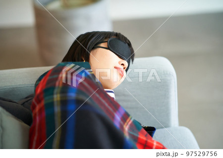 アイマスクをつけて横になる若い女性 97529756