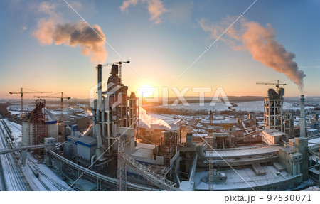 Aerial view of cement factory with high concrete plant structure and tower crane at industrial production area in evening. Manufacture and global industry concept Aerial view of cement factory with high concrete plant structure and tower crane at industrial production area in evening. Manufacture and global industry concept 97530071