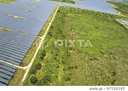 Aerial view of big sustainable electric power plant with many rows of solar photovoltaic panels for producing clean electrical energy. Renewable electricity with zero emission concept Aerial view of big sustainable electric power plant with many rows of solar photovoltaic panels for producing clean electrical energy. Renewable electricity with zero emission concept 97530185