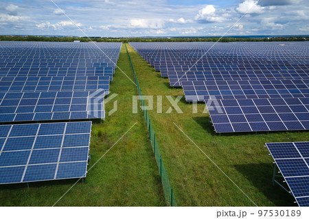 Aerial view of big sustainable electric power plant with many rows of solar photovoltaic panels for producing clean electrical energy. Renewable electricity with zero emission concept 97530189
