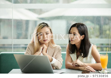 Female entrepreneurs watching product presentation on laptop screen at meeting 97530856