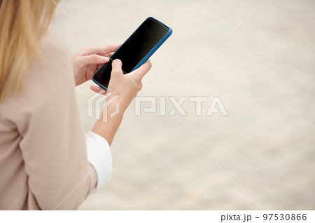 Hands of female entrepreneur answering messages on sartphone 97530866