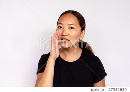 Close-up of young woman whispering secret 97532630