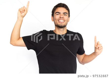 Excited young man pointing fingers up 97532887