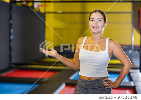 Woman trampolining coach against the background of children playing and jumping on a trampoline 97535349